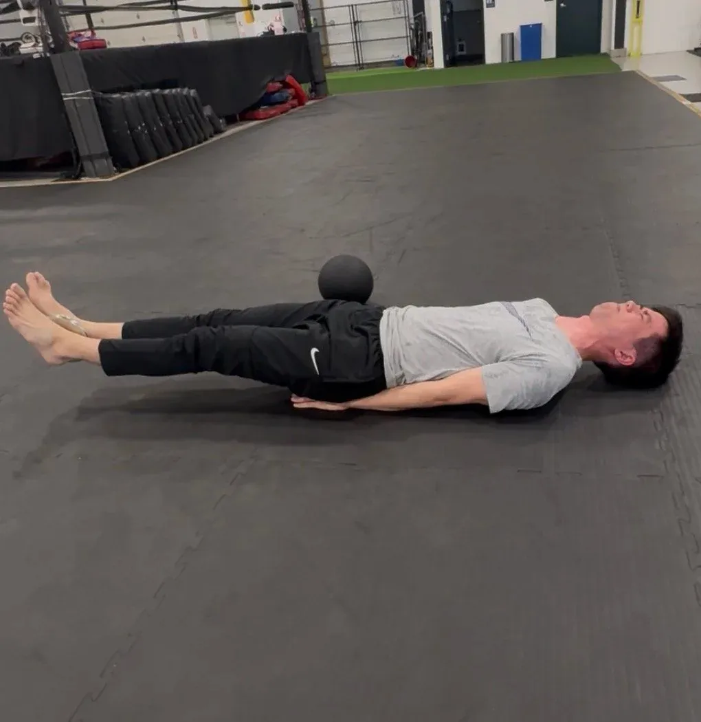 A student practicing supine core control and breathing work on the mat